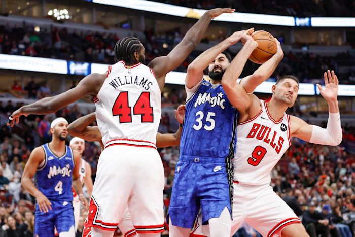 Orlando Magic center Goga Bitadze (35) battles for the ball with Chicago Bulls forward Patrick Williams (44) and center Nikola Vucevic (9) during the second half at United Center.